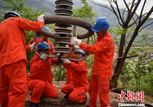 圖為電力工人首次在特高壓復(fù)奉線重慶段開(kāi)展整串絕緣子串更換工作。　周毅 攝